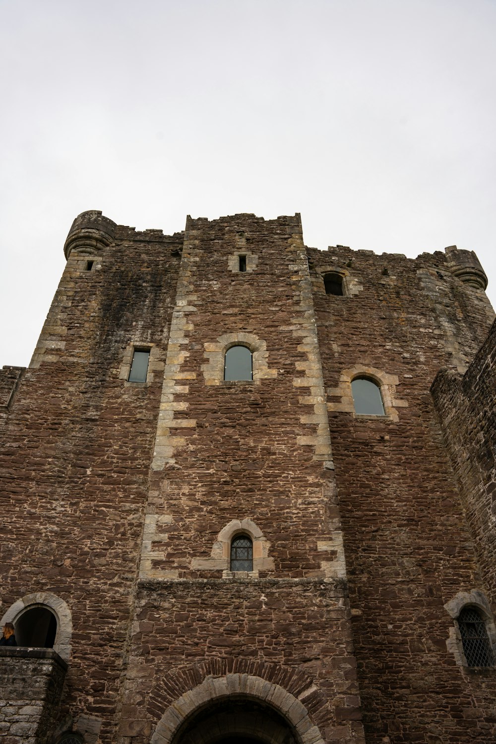 a very tall brick building with a clock on it's side