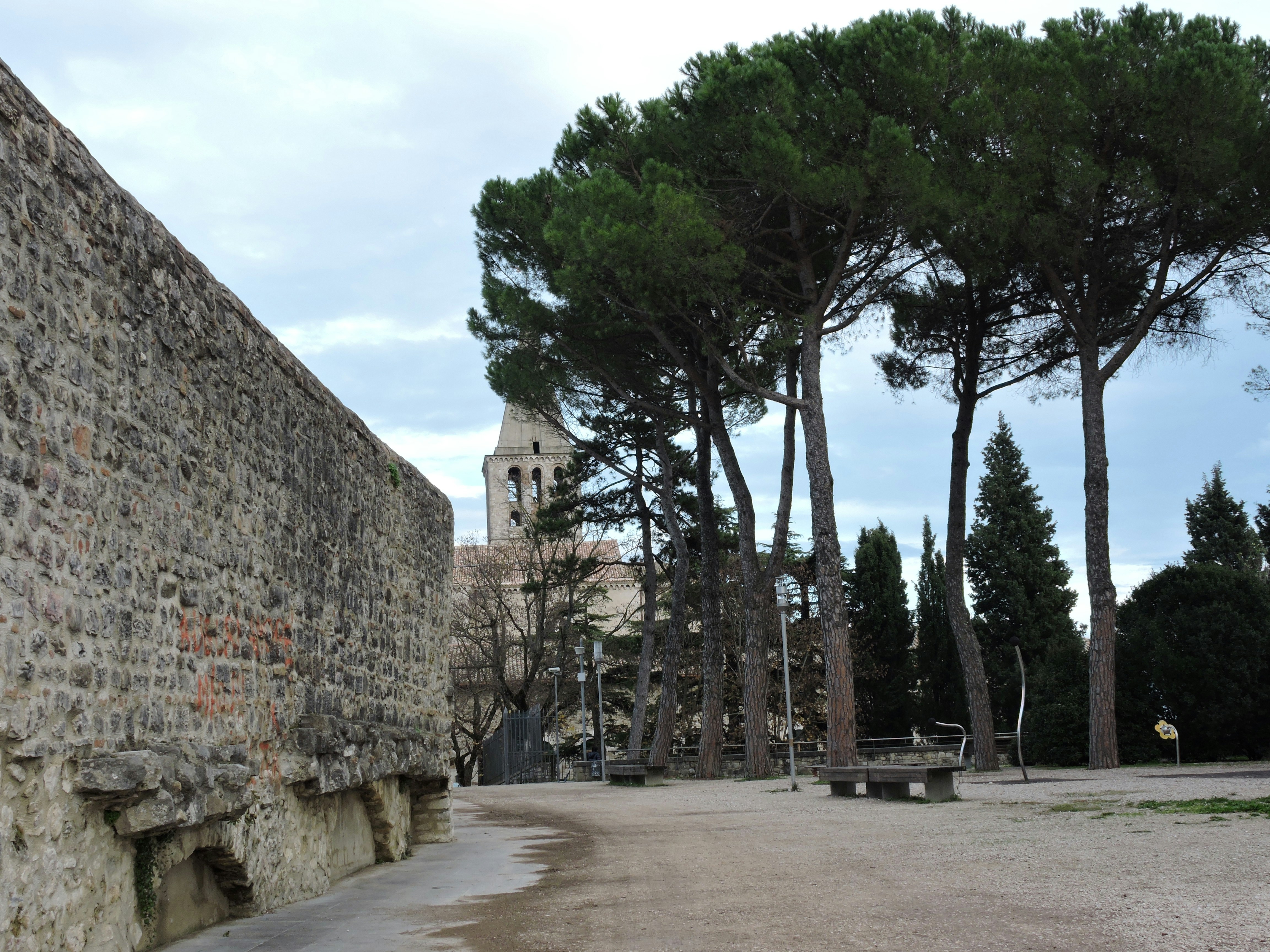 a stone wall with trees in the background