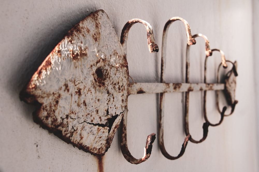 a rusted metal hook on a white wall