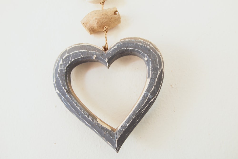 a wooden heart hanging from a string on a wall