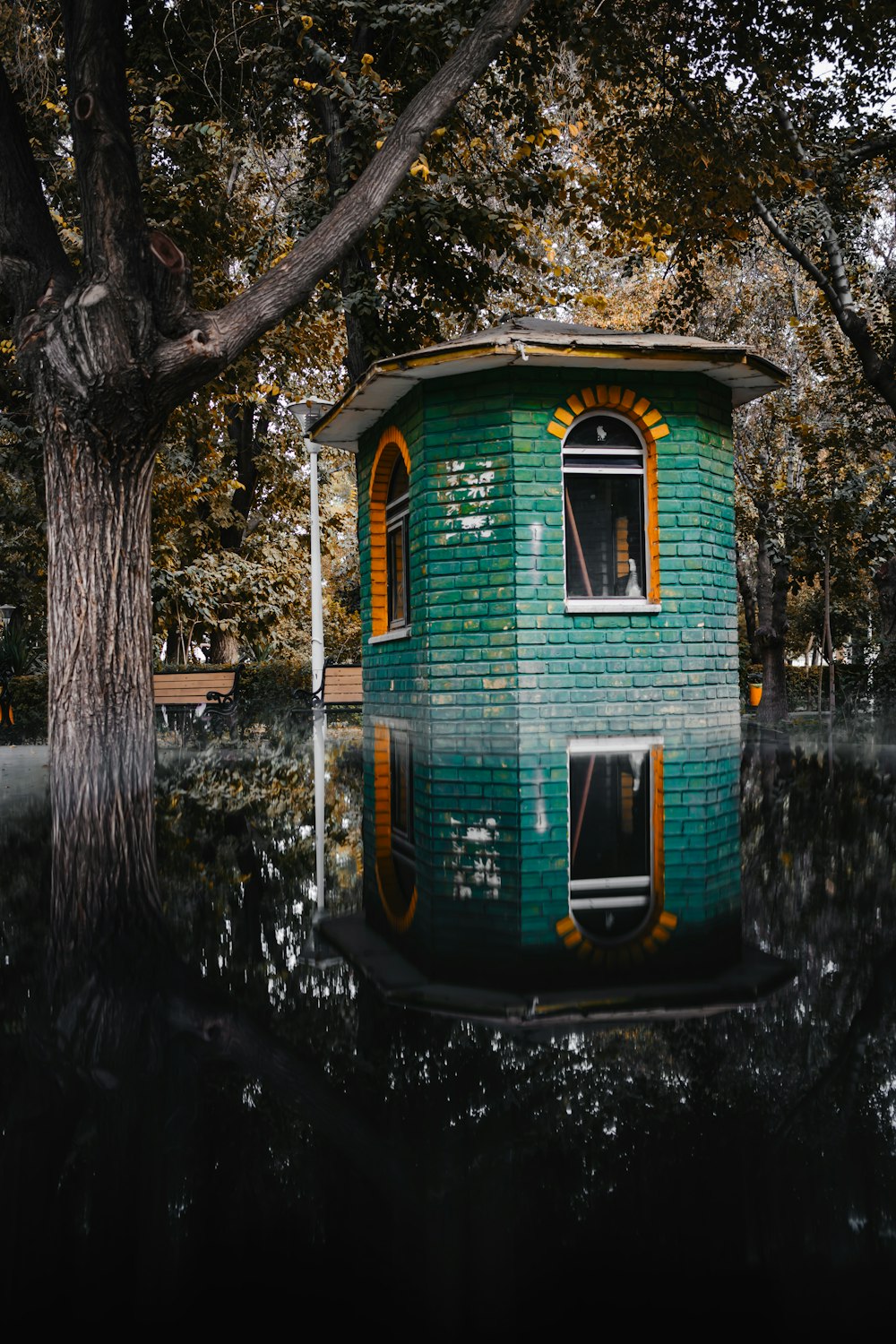 a green house sitting on top of a body of water