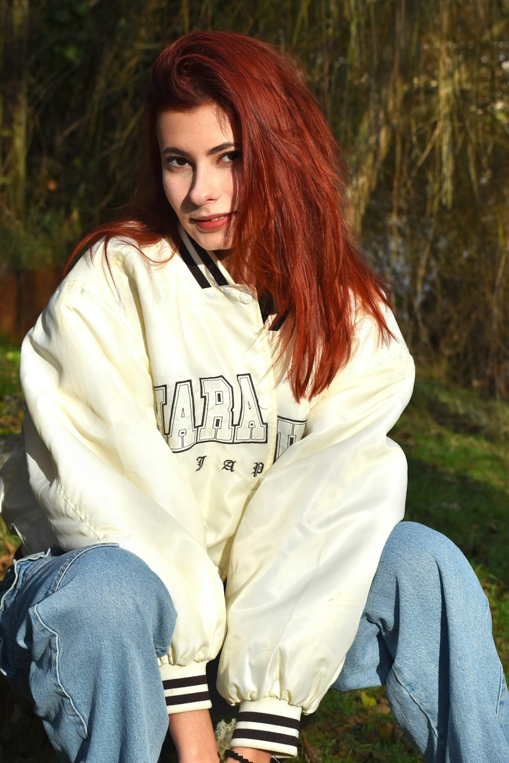 a woman with red hair sitting on a bench