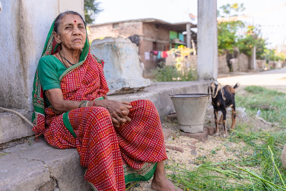 a woman sitting on a step next to a dog