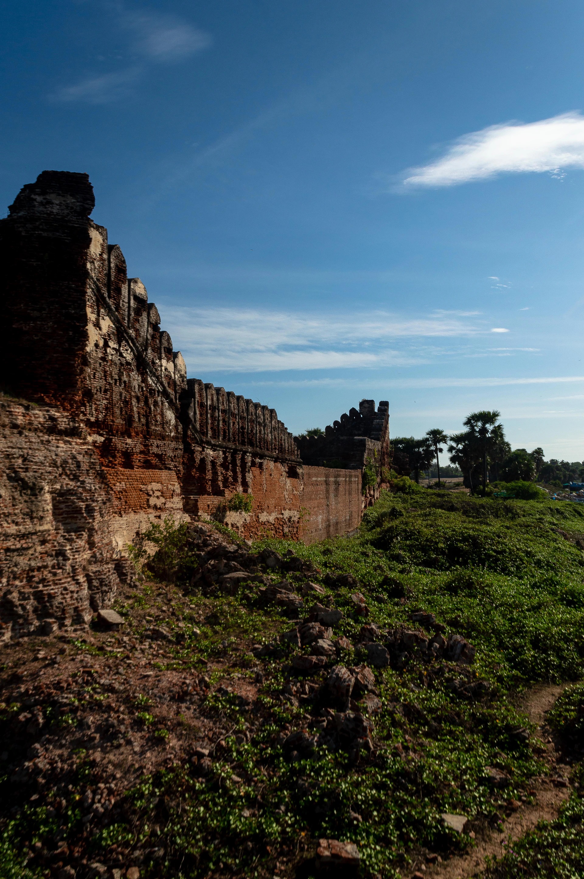 a very tall brick structure sitting on top of a lush green hillside