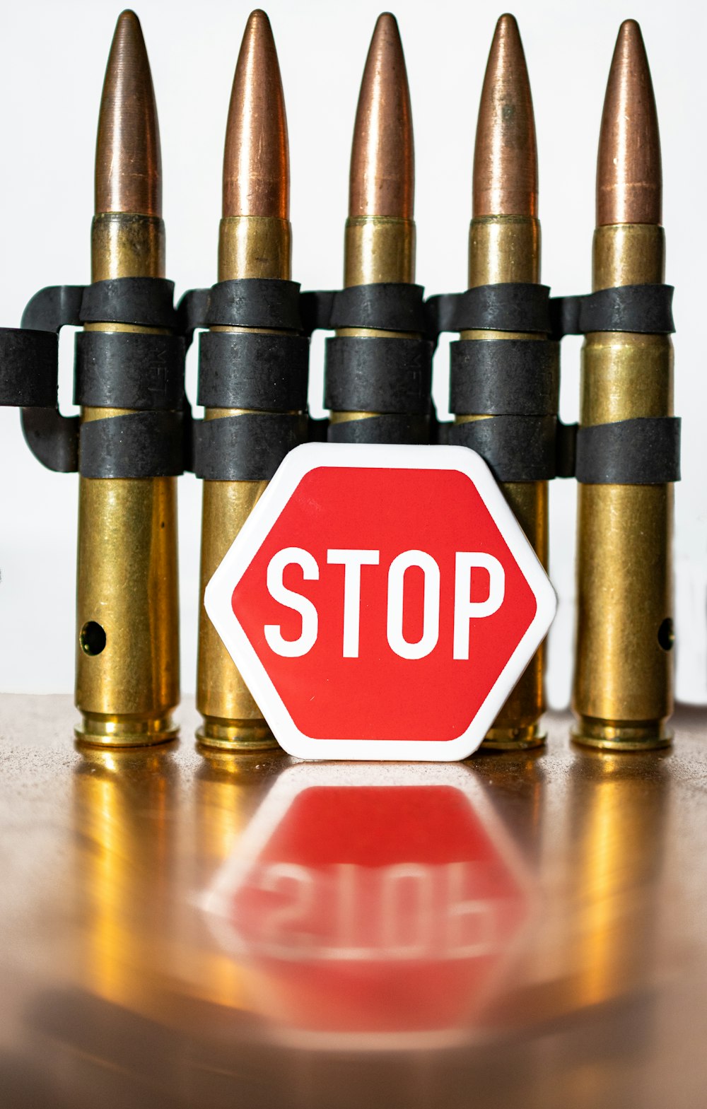 a close up of a stop sign near some bullet shells
