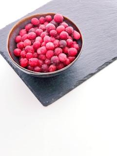 a bowl of raspberries sitting on top of a table