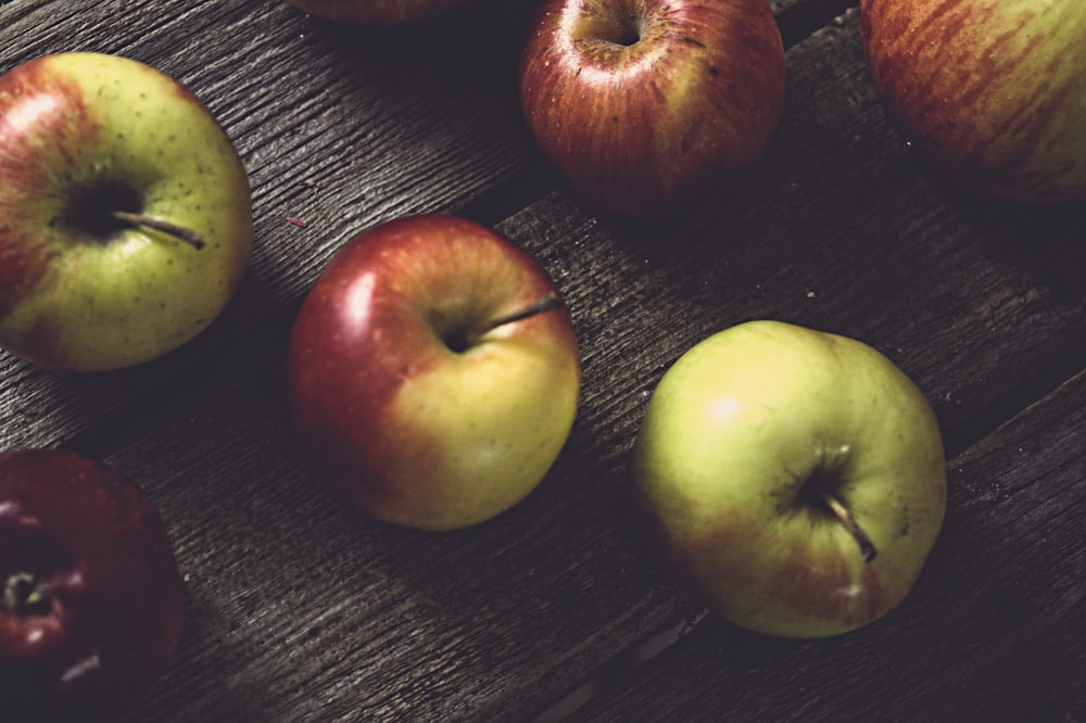 a group of apples sitting on top of a wooden table