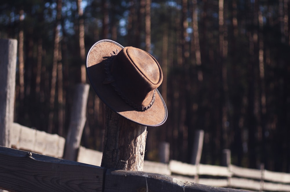 a brown hat sitting on top of a wooden fence