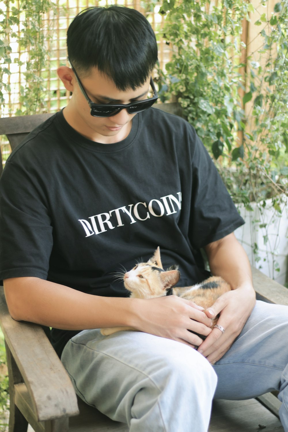 a man sitting on a bench holding a cat