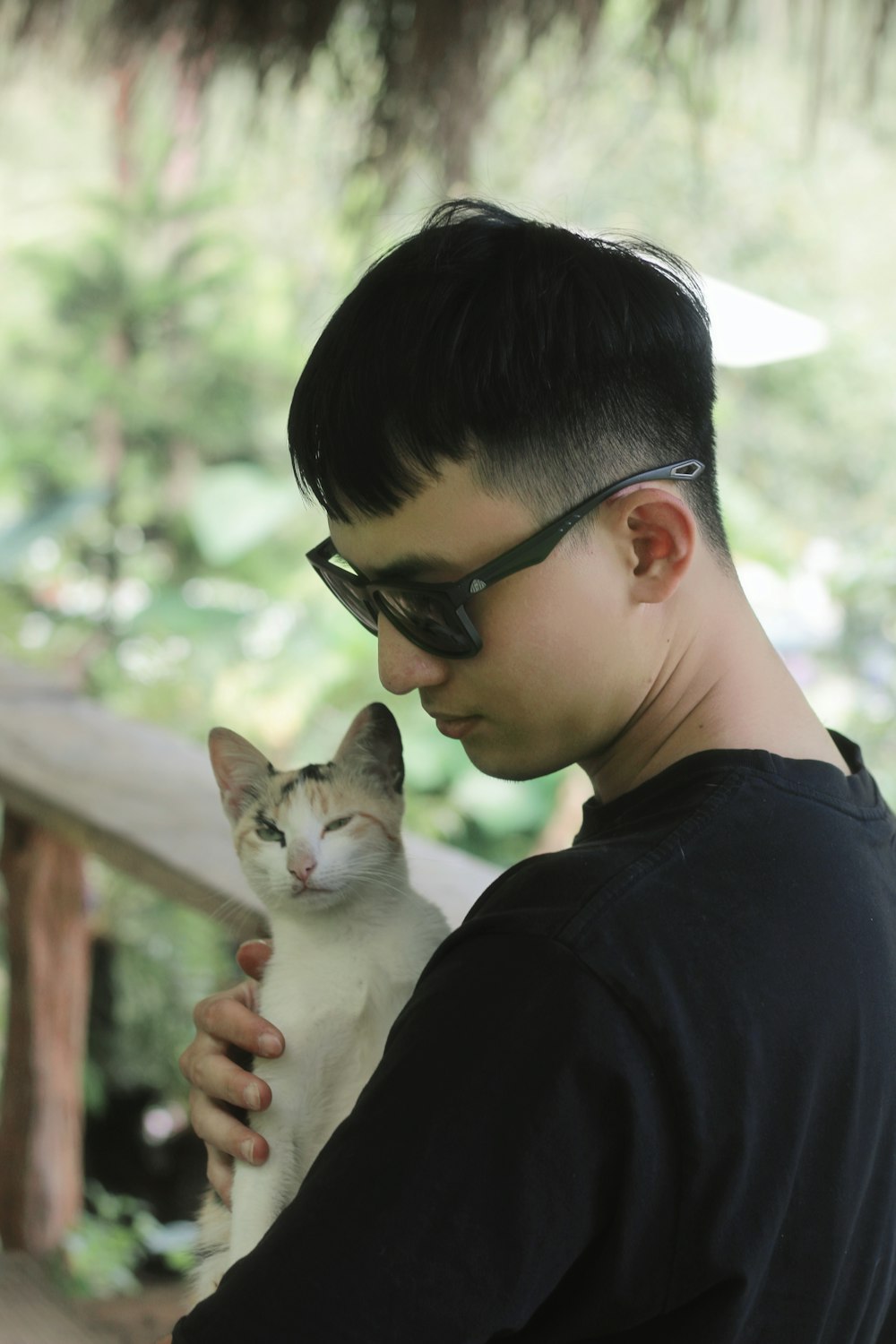 a young man holding a cat in his arms