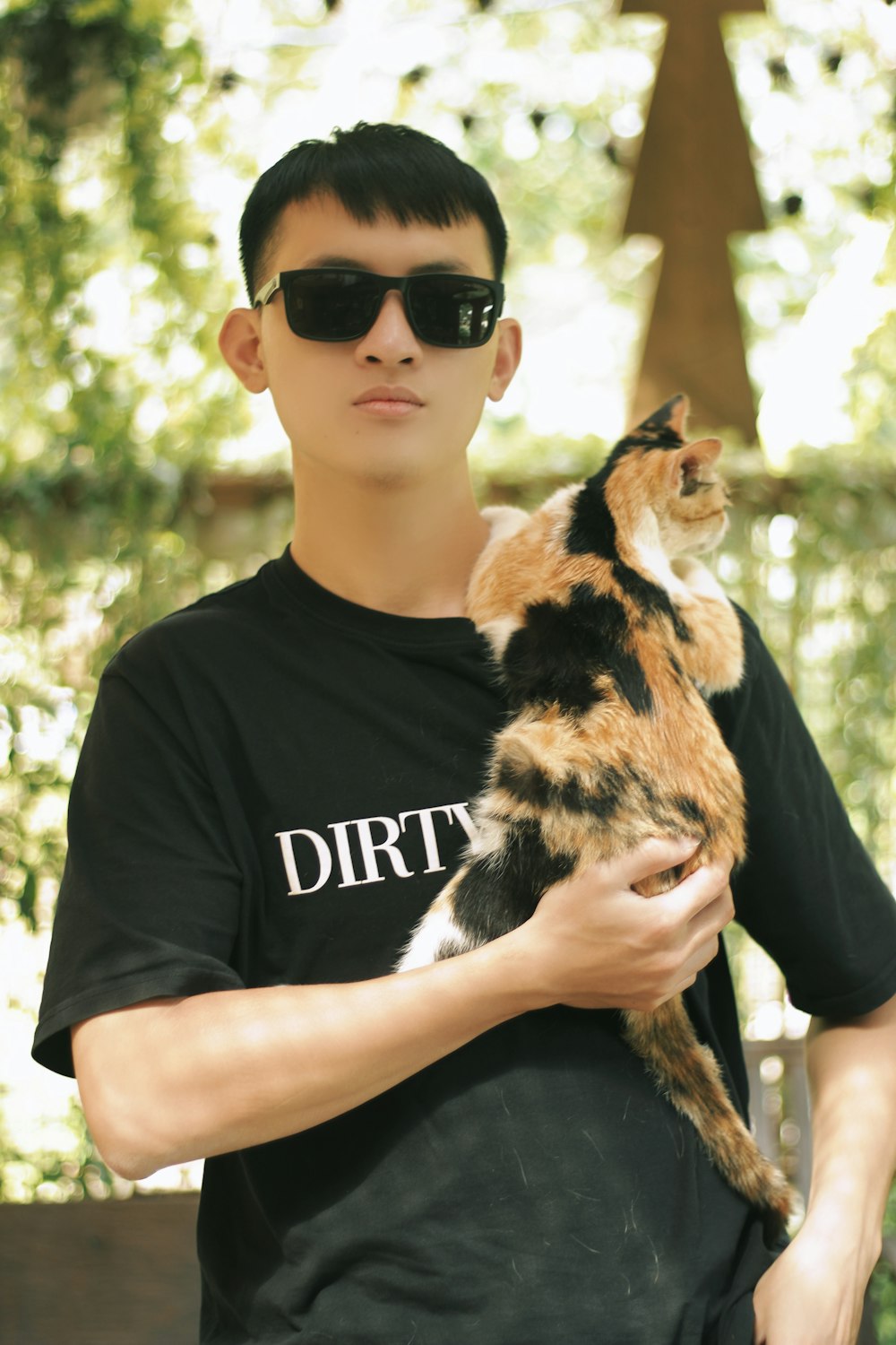 a man in a black shirt holding a cat