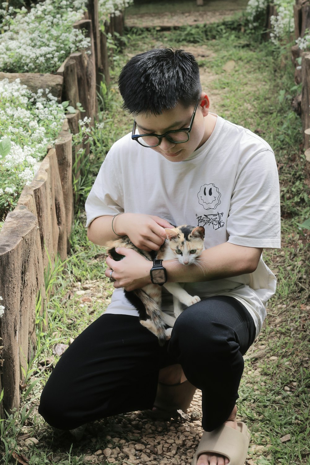 a young man holding a cat in his hands