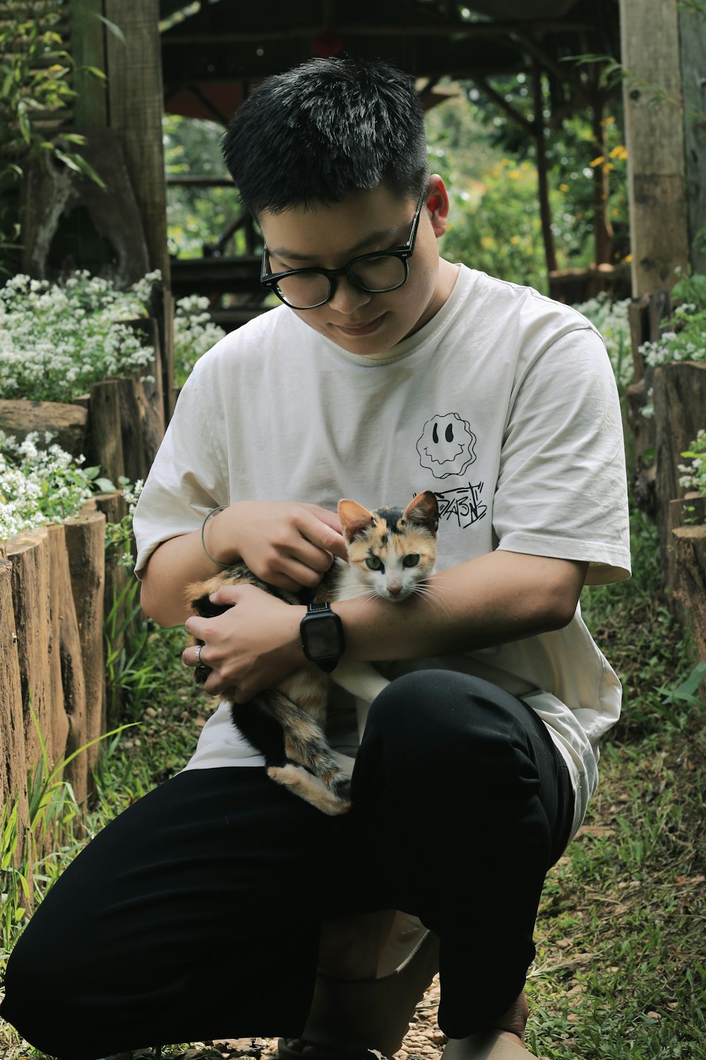 a man holding a small kitten in his hands