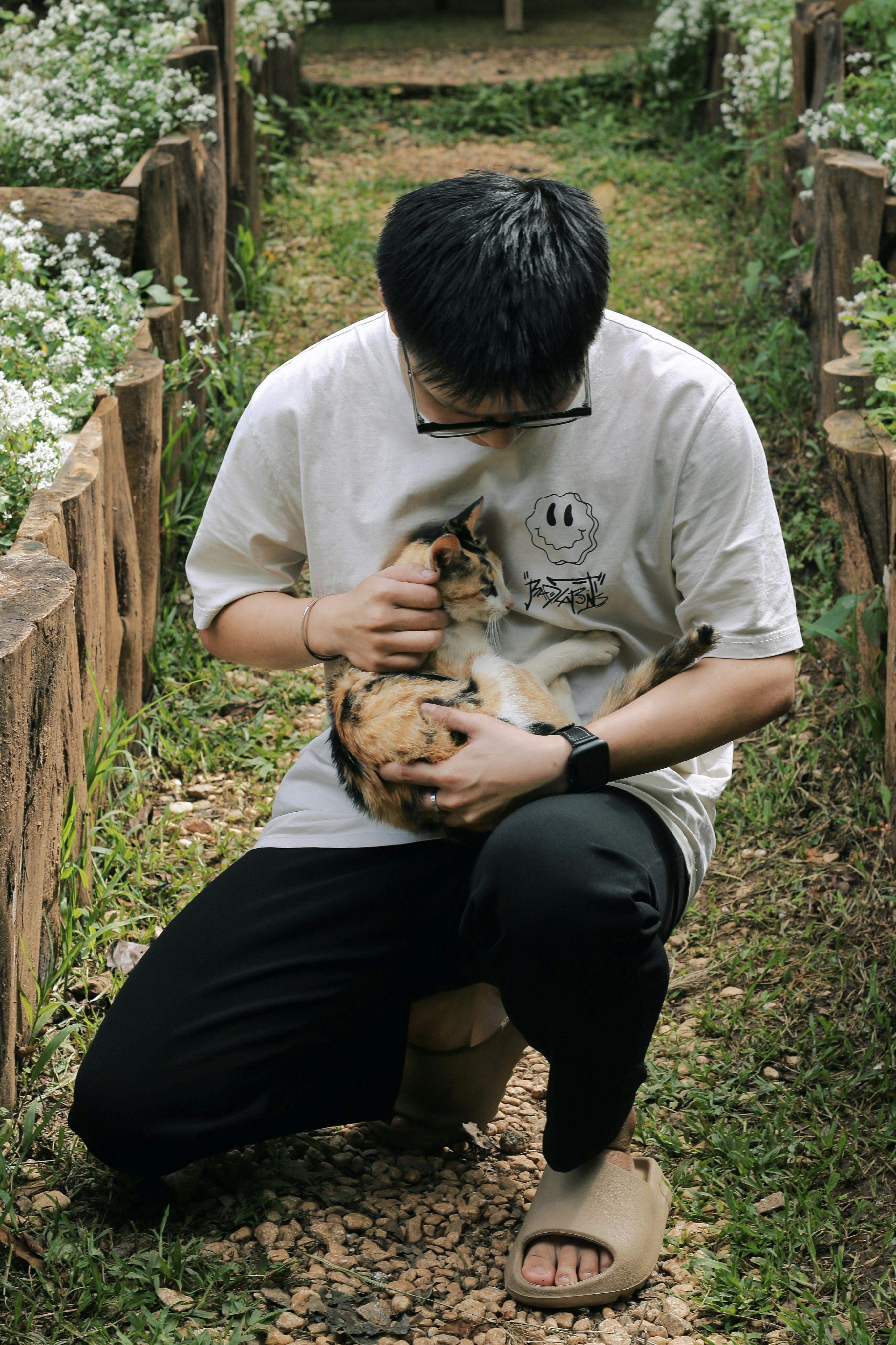 a young man holding a cat in his hands