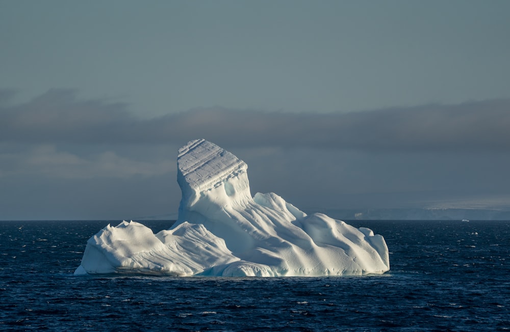 a large iceberg floating in the middle of the ocean