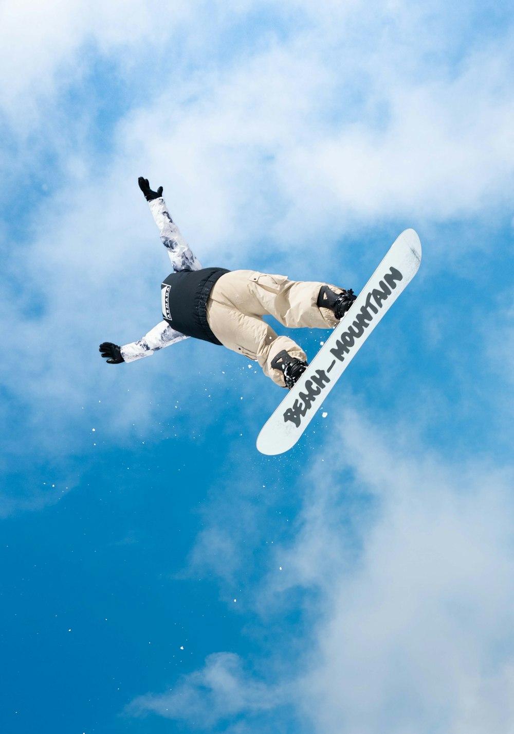 a man flying through the air while riding a snowboard