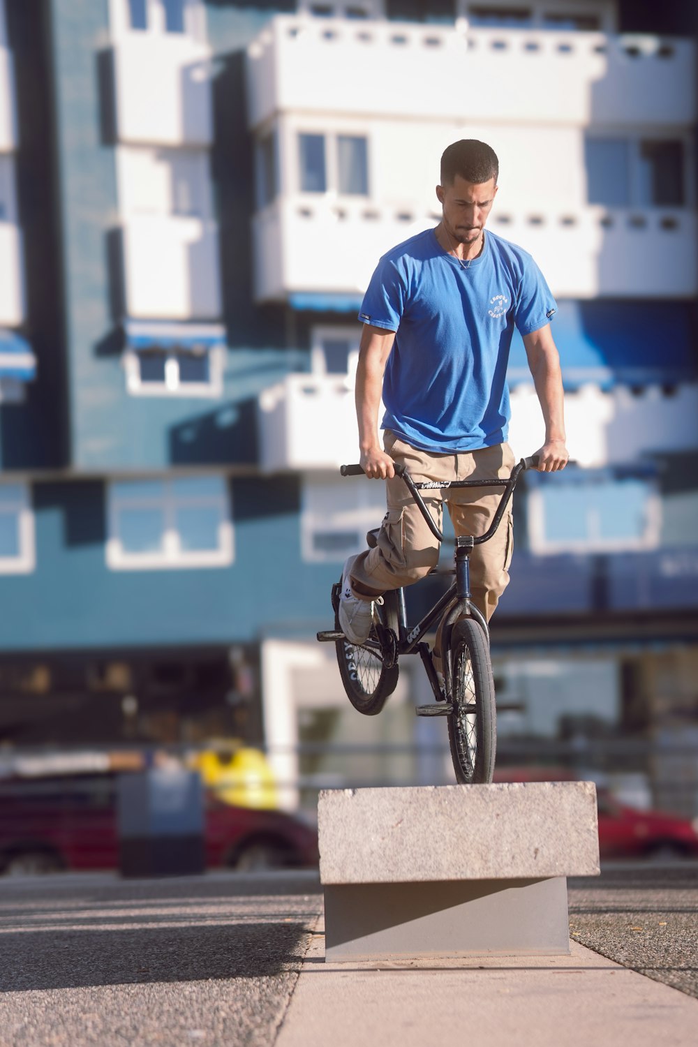 Un hombre montando una bicicleta encima de un bloque de cemento