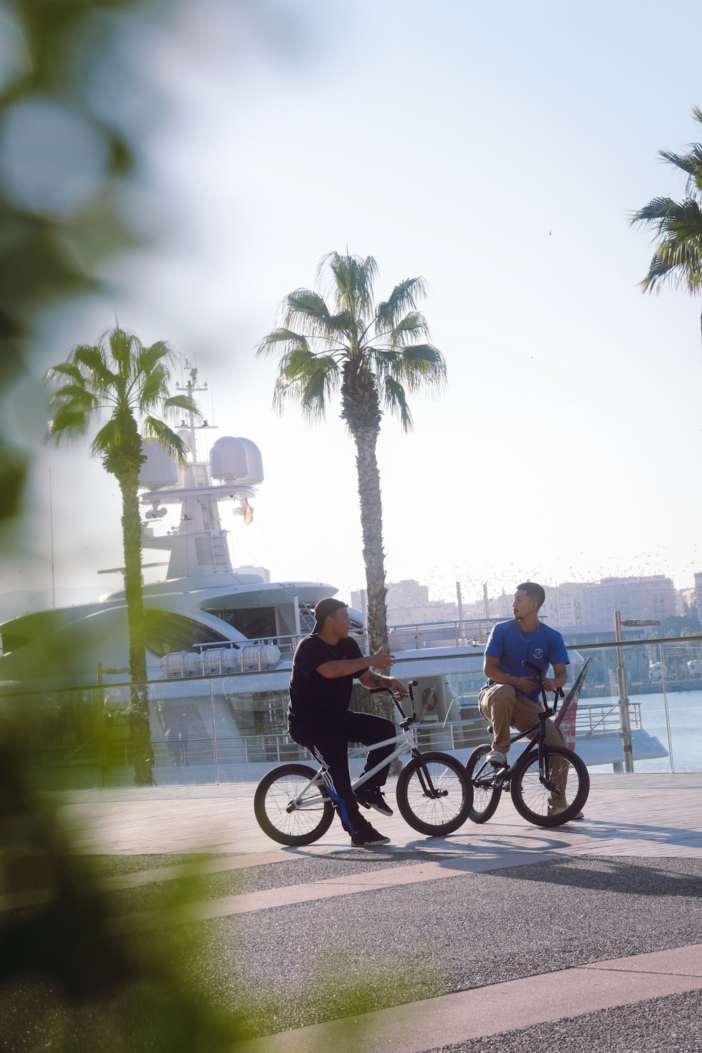 a couple of people riding bikes next to a body of water