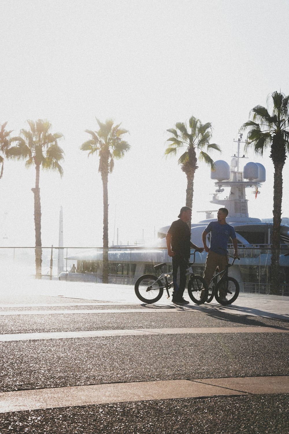 Dos hombres parados junto a una motocicleta en una calle