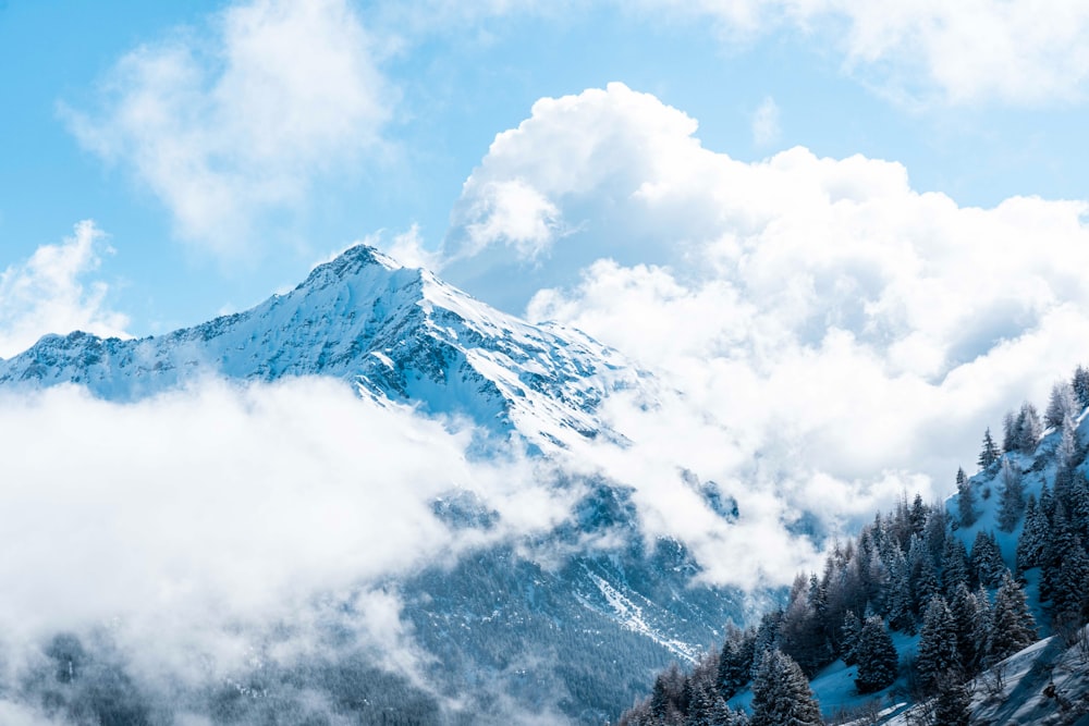 青空の下、雪と雲に覆われた山