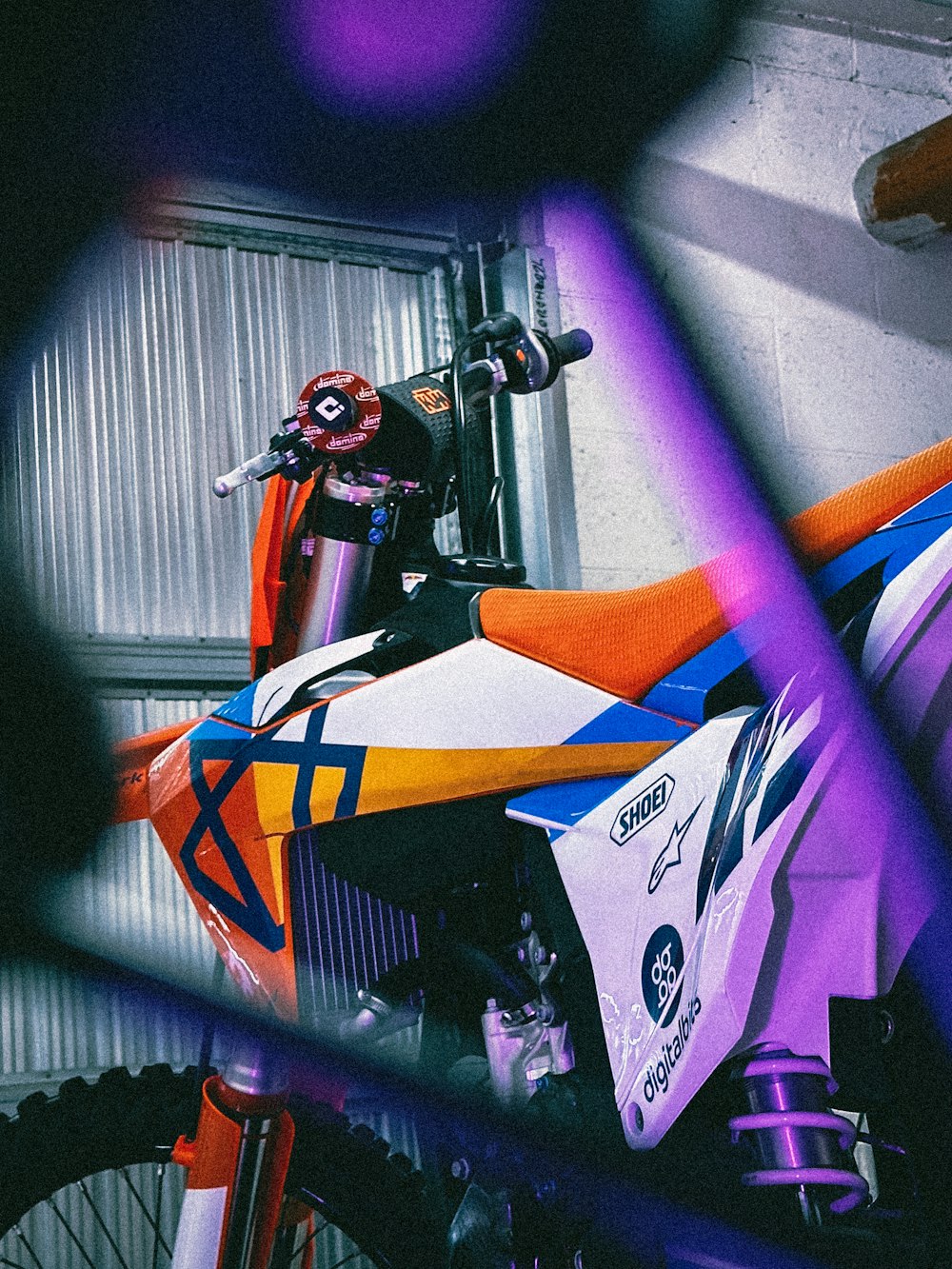 a colorful dirt bike parked next to a building