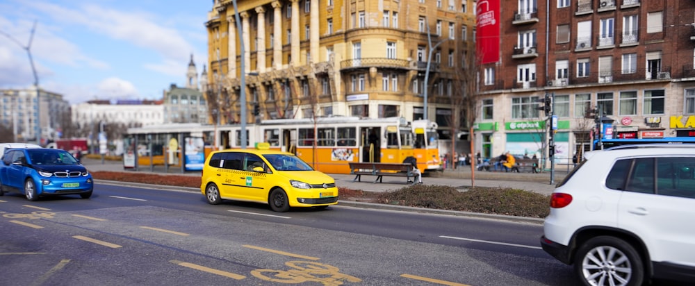 a yellow taxi cab driving down a street next to tall buildings