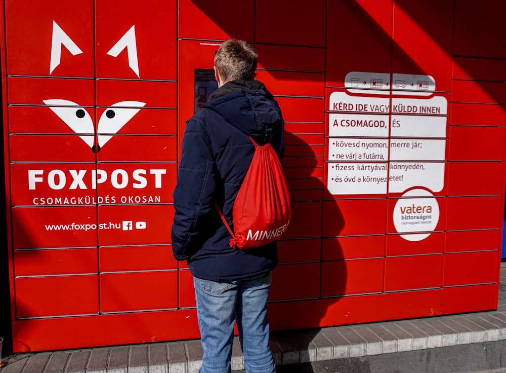 a person standing in front of a red wall