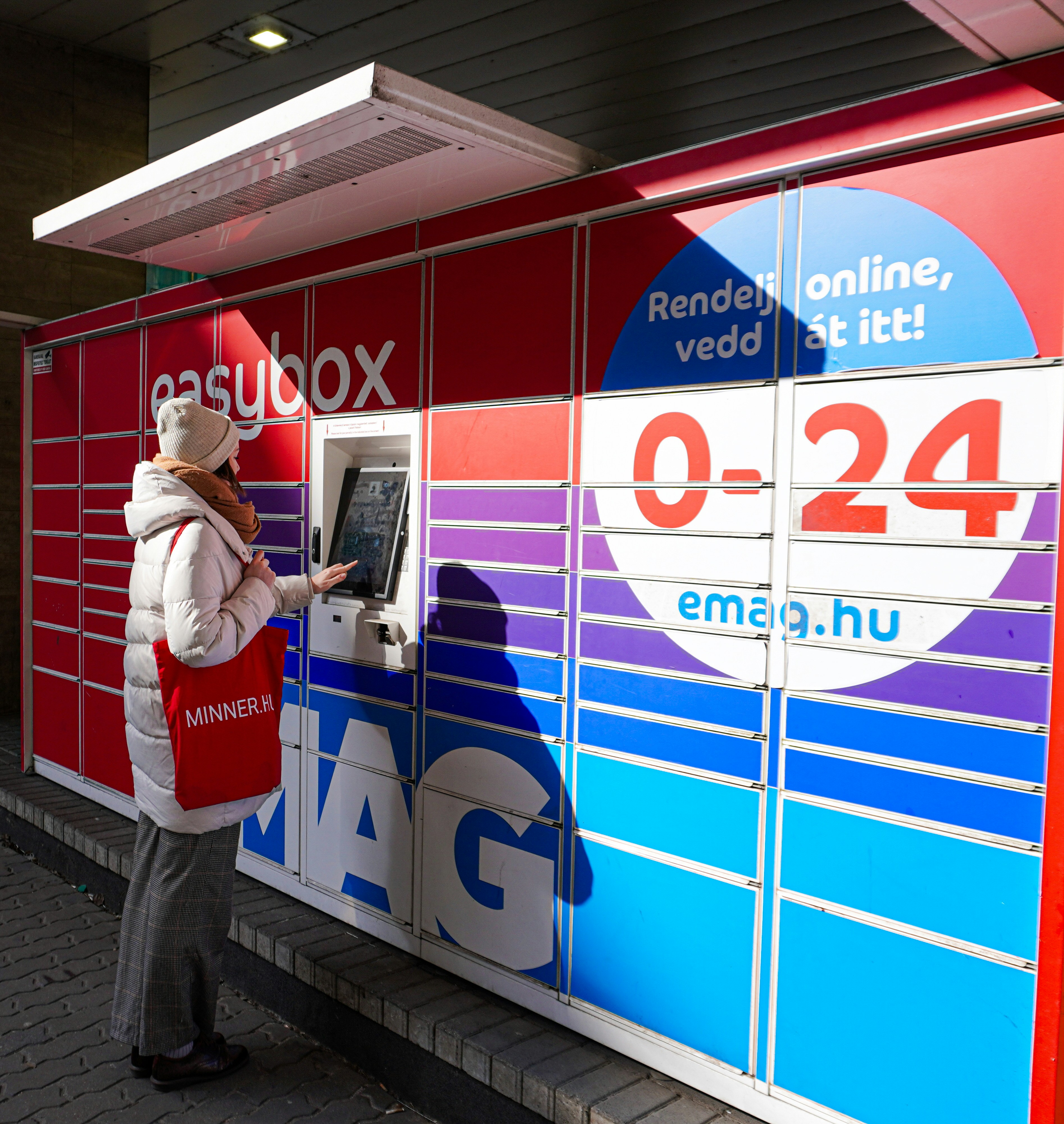 a woman using an atm machine in front of a store