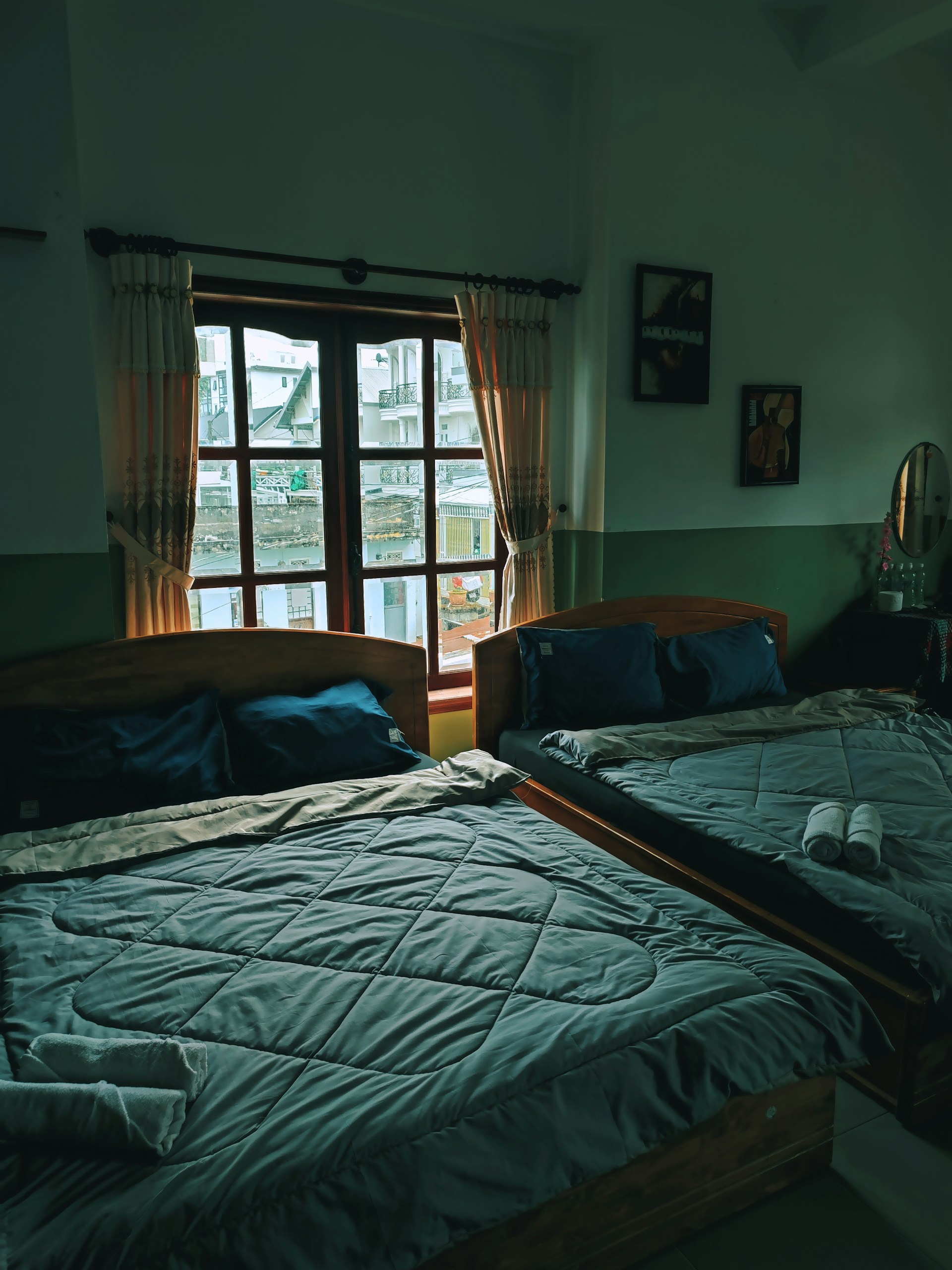 a couple of beds sitting in a bedroom next to a window