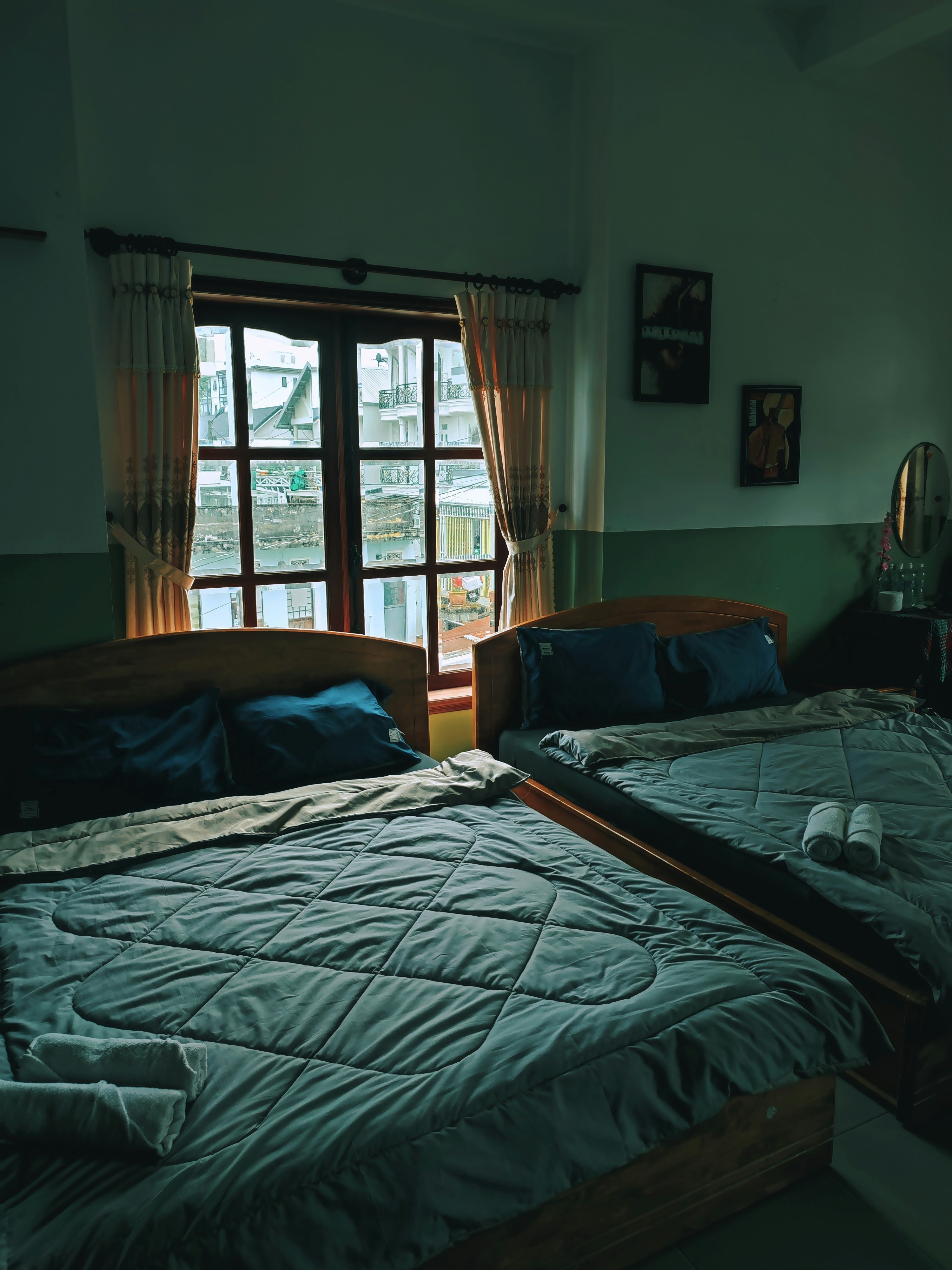 a couple of beds sitting in a bedroom next to a window