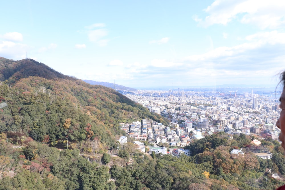 a woman looking out over a city from a hill