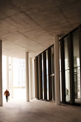 a person walking down a hallway between two buildings