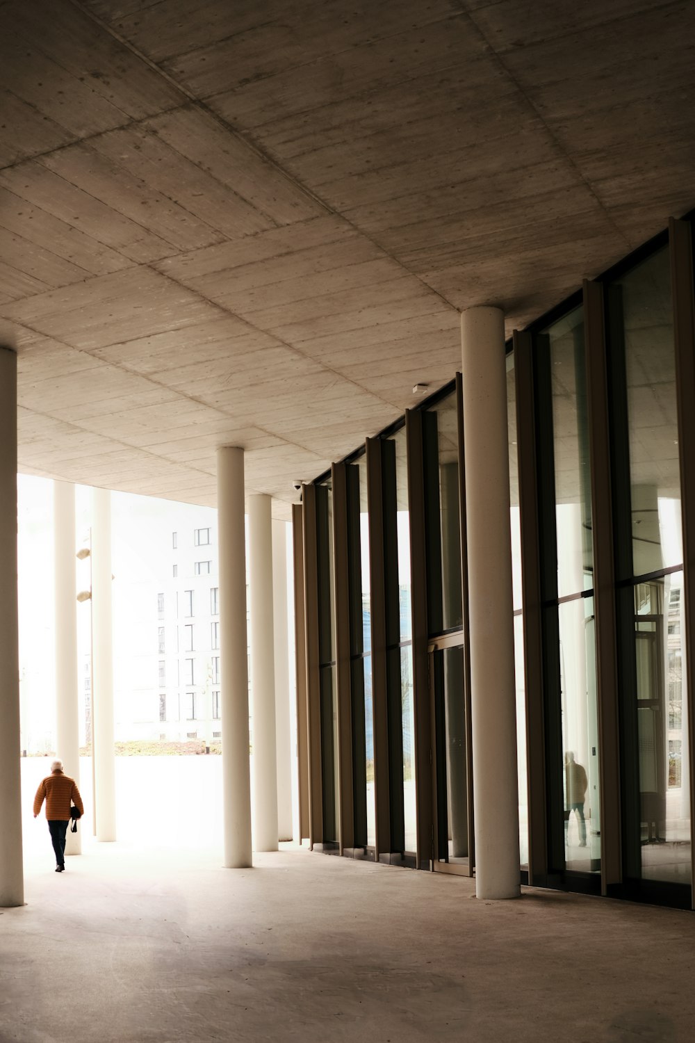 a person walking down a hallway between two buildings