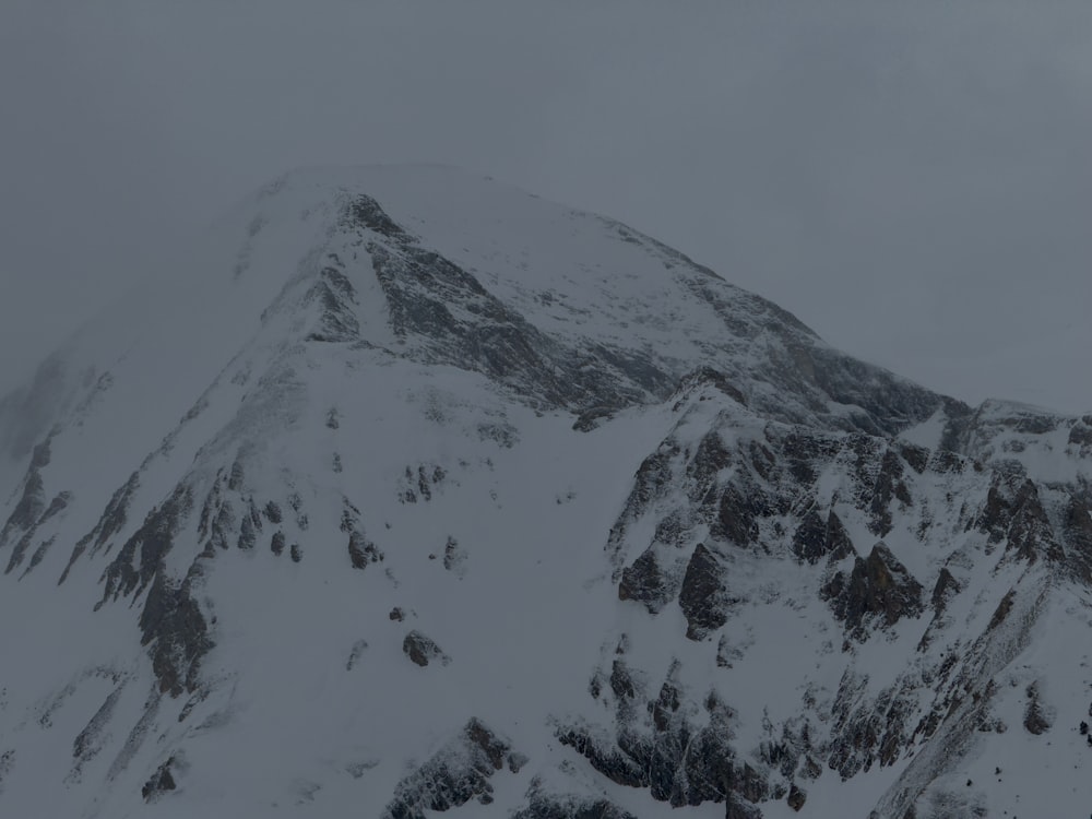 a mountain covered in snow with a sky background