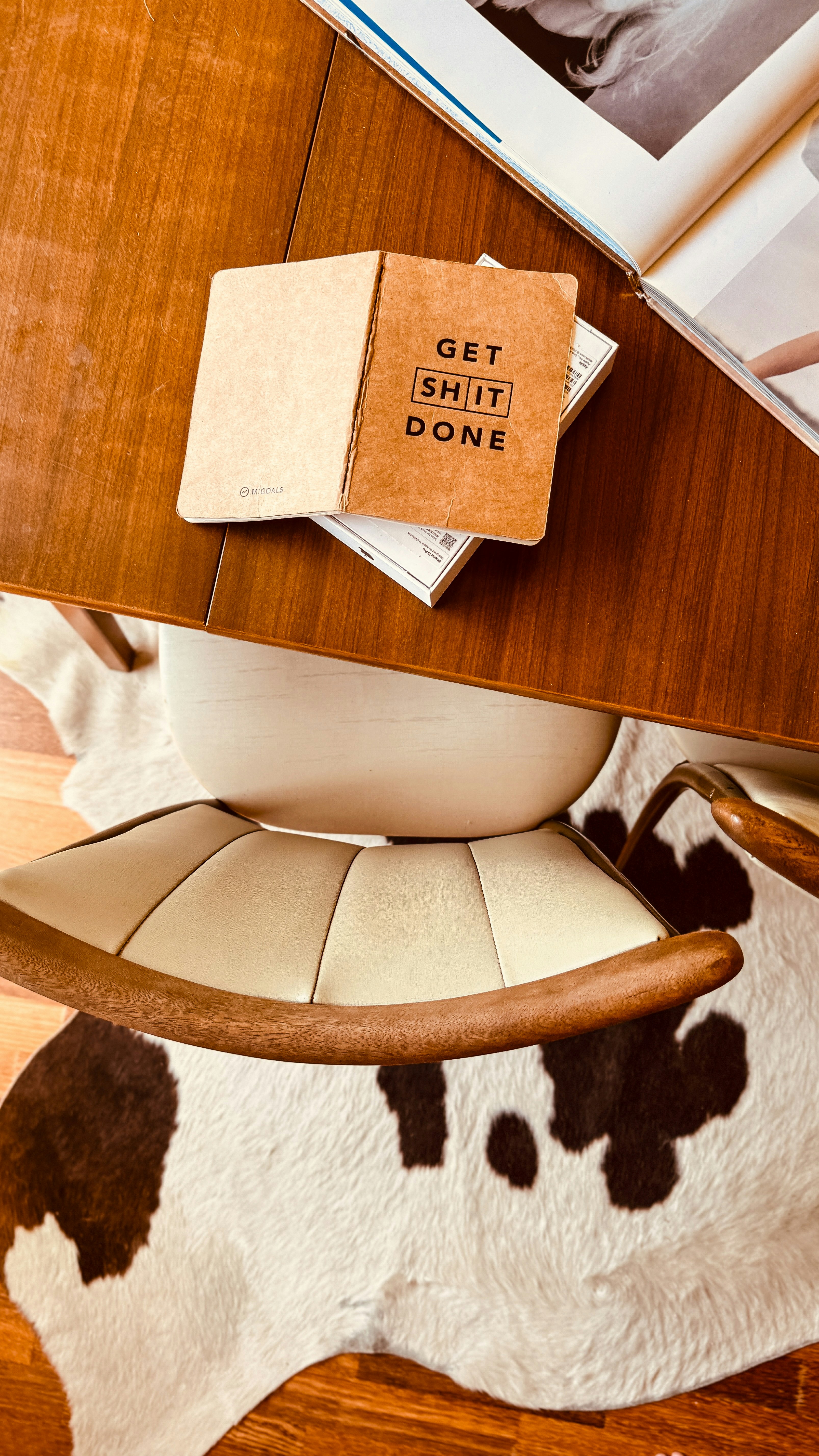 una alfombra de vaca y una silla con un libro encima