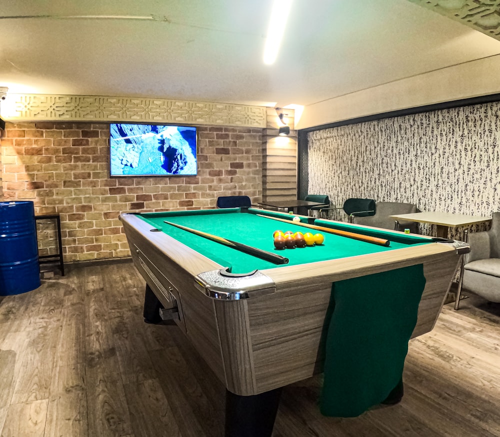 une chambre avec une table de billard et une télévision