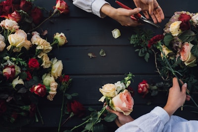 a couple of people cutting flowers with scissors