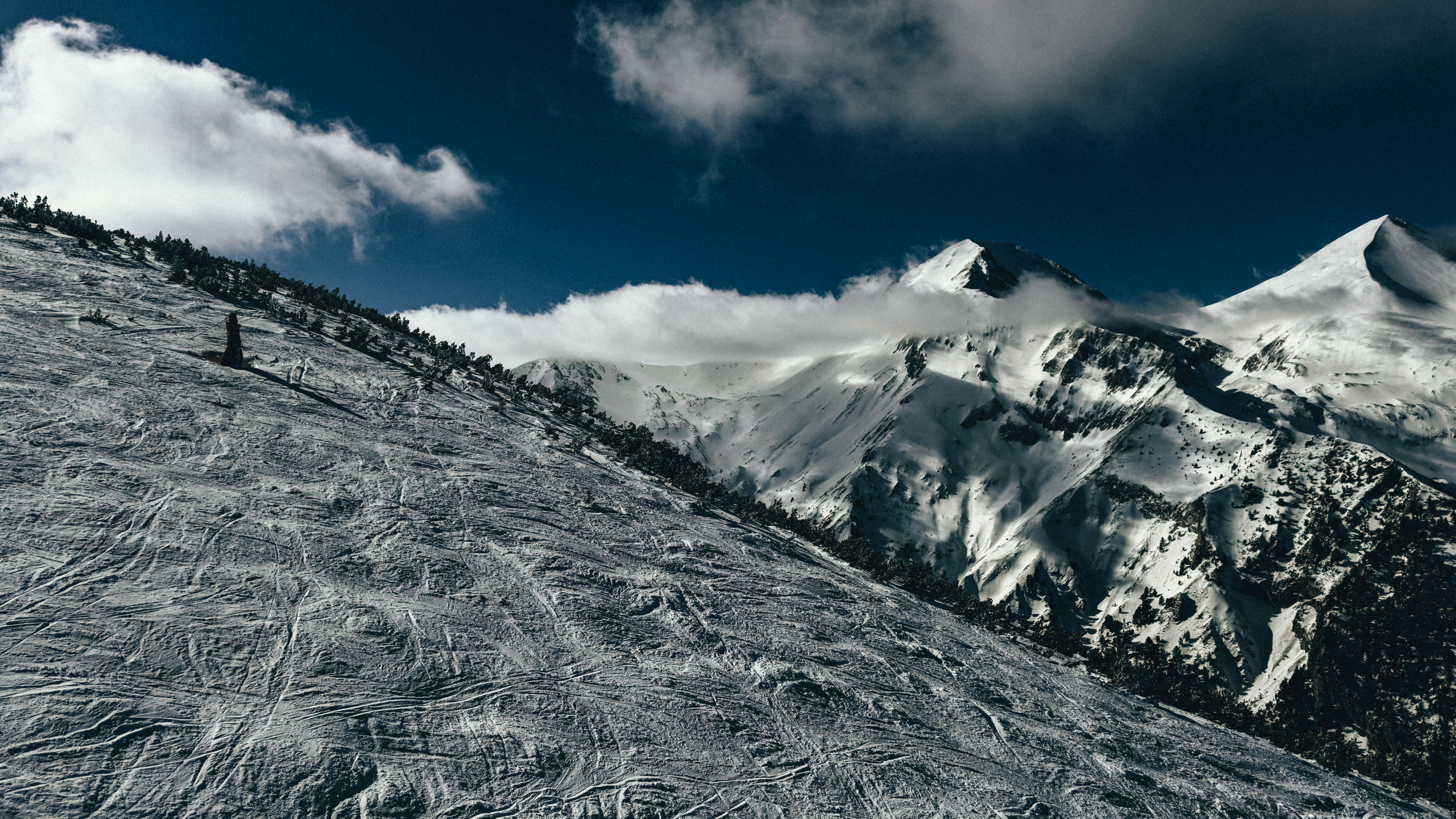 a man riding skis down the side of a snow covered slope, 