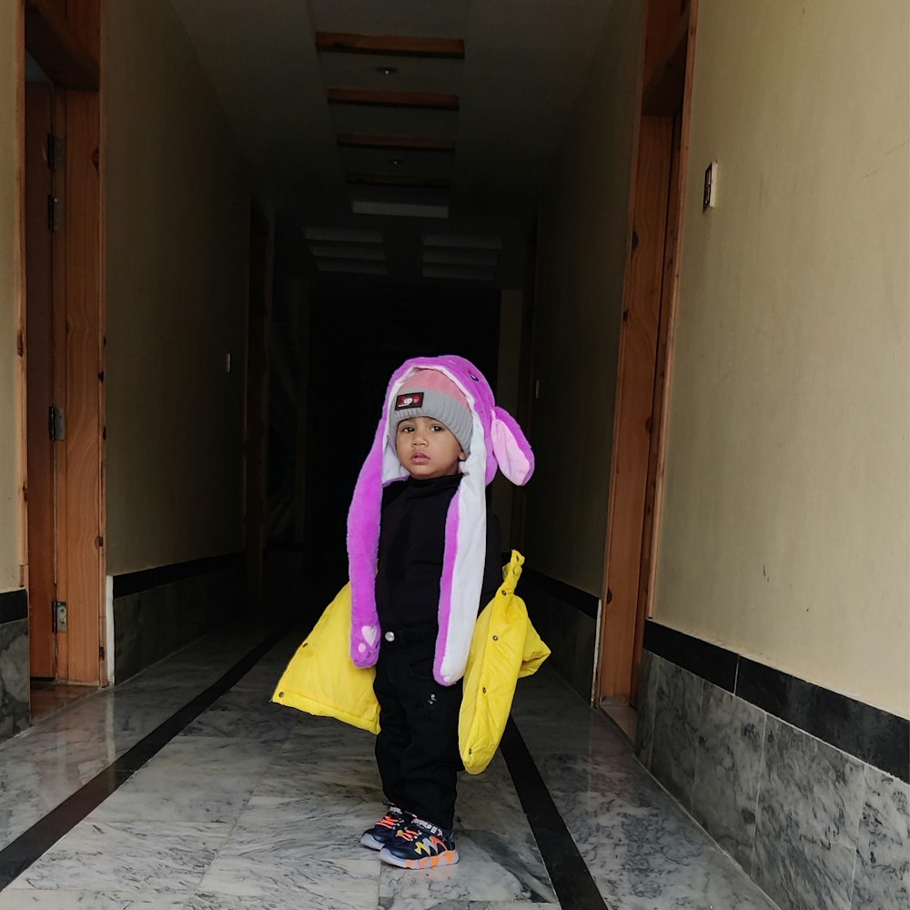 a small child in a bunny costume standing in a hallway