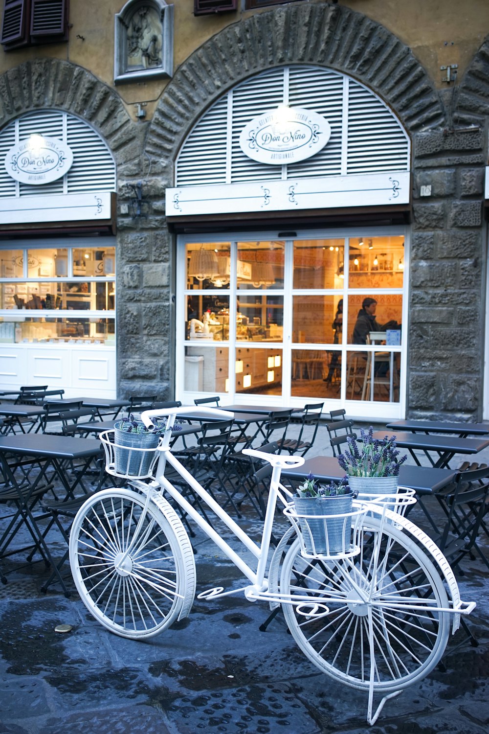 a white bicycle parked in front of a building