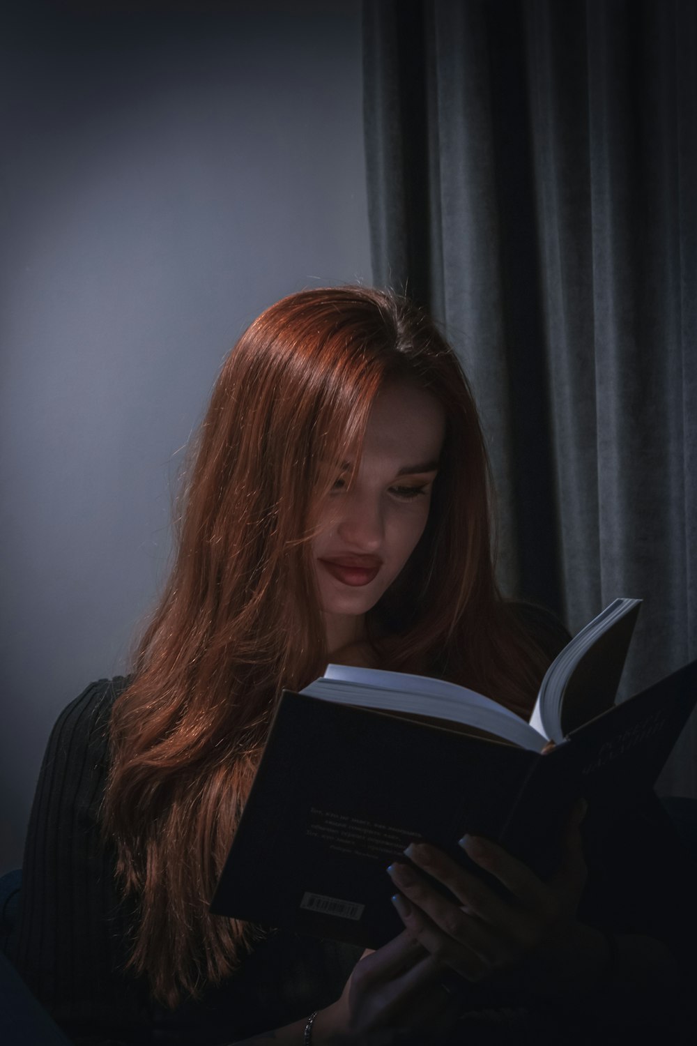 a woman reading a book in the dark