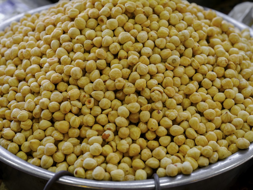 a large metal bowl filled with yellow peas