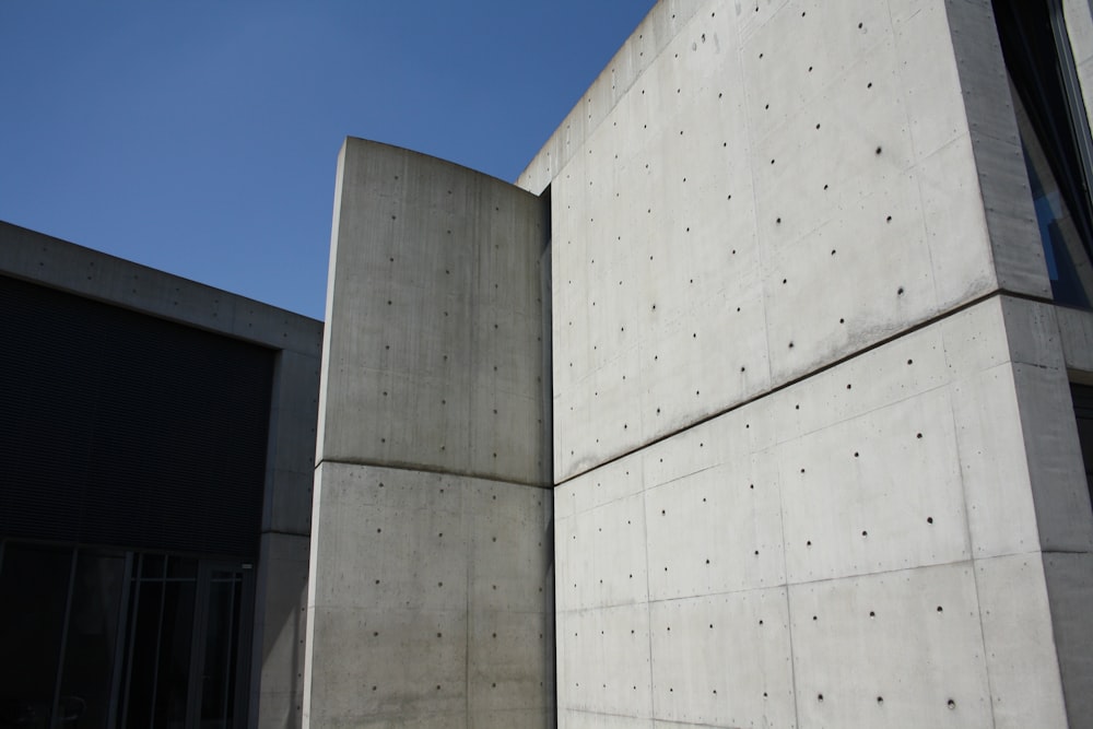 a building made of concrete with a blue sky in the background