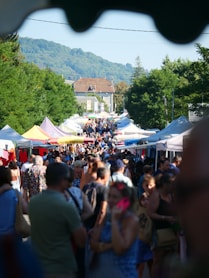 a crowd of people walking down a street next to tents