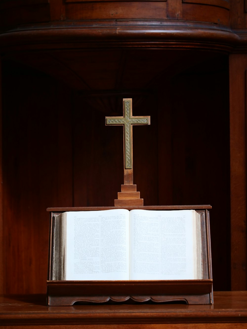 an open book with a cross on top of it