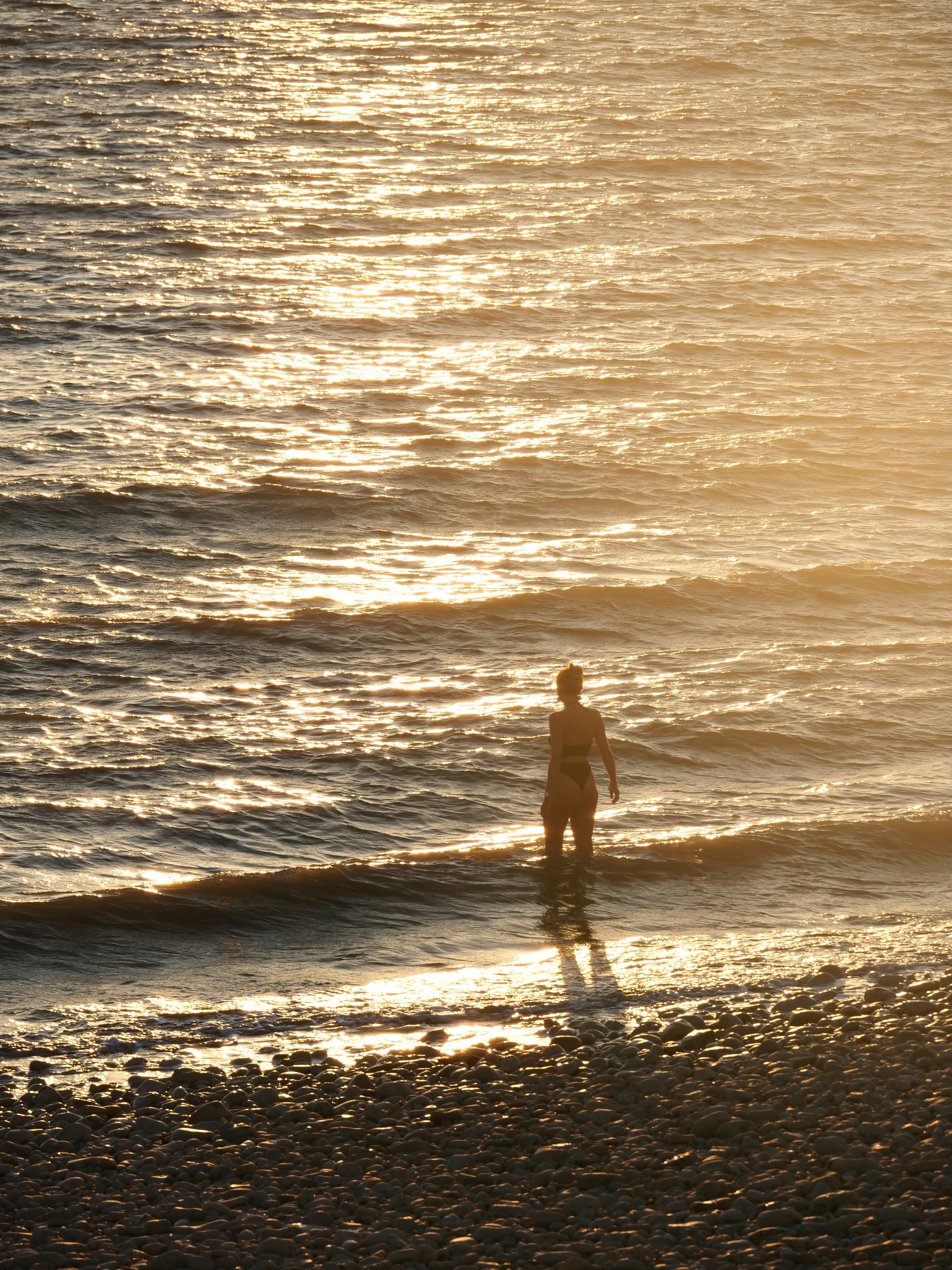 a man standing on a beach next to the ocean