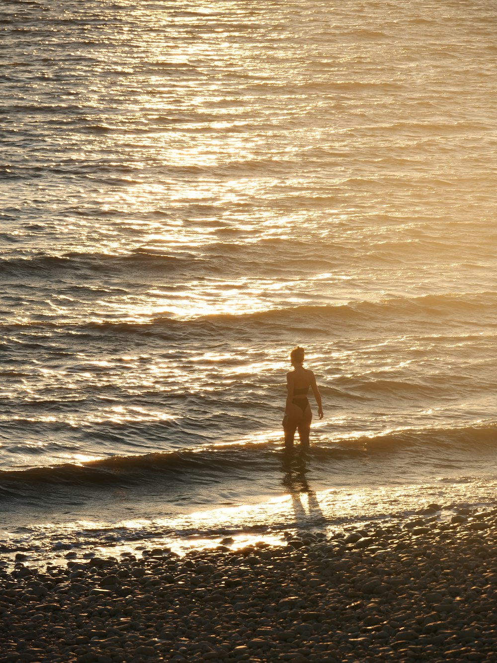 a man standing on a beach next to the ocean