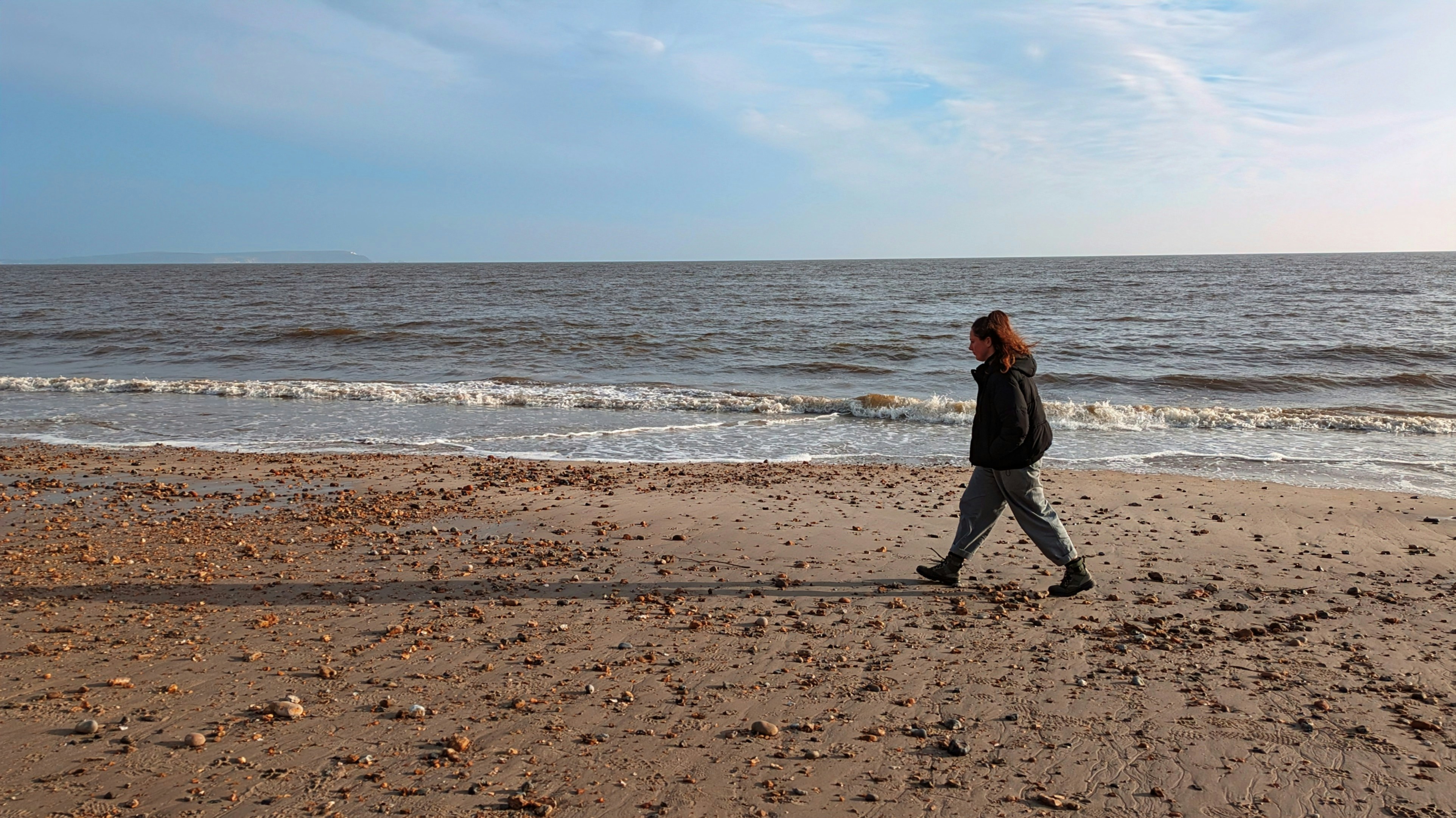 a person walking on a beach near the ocean