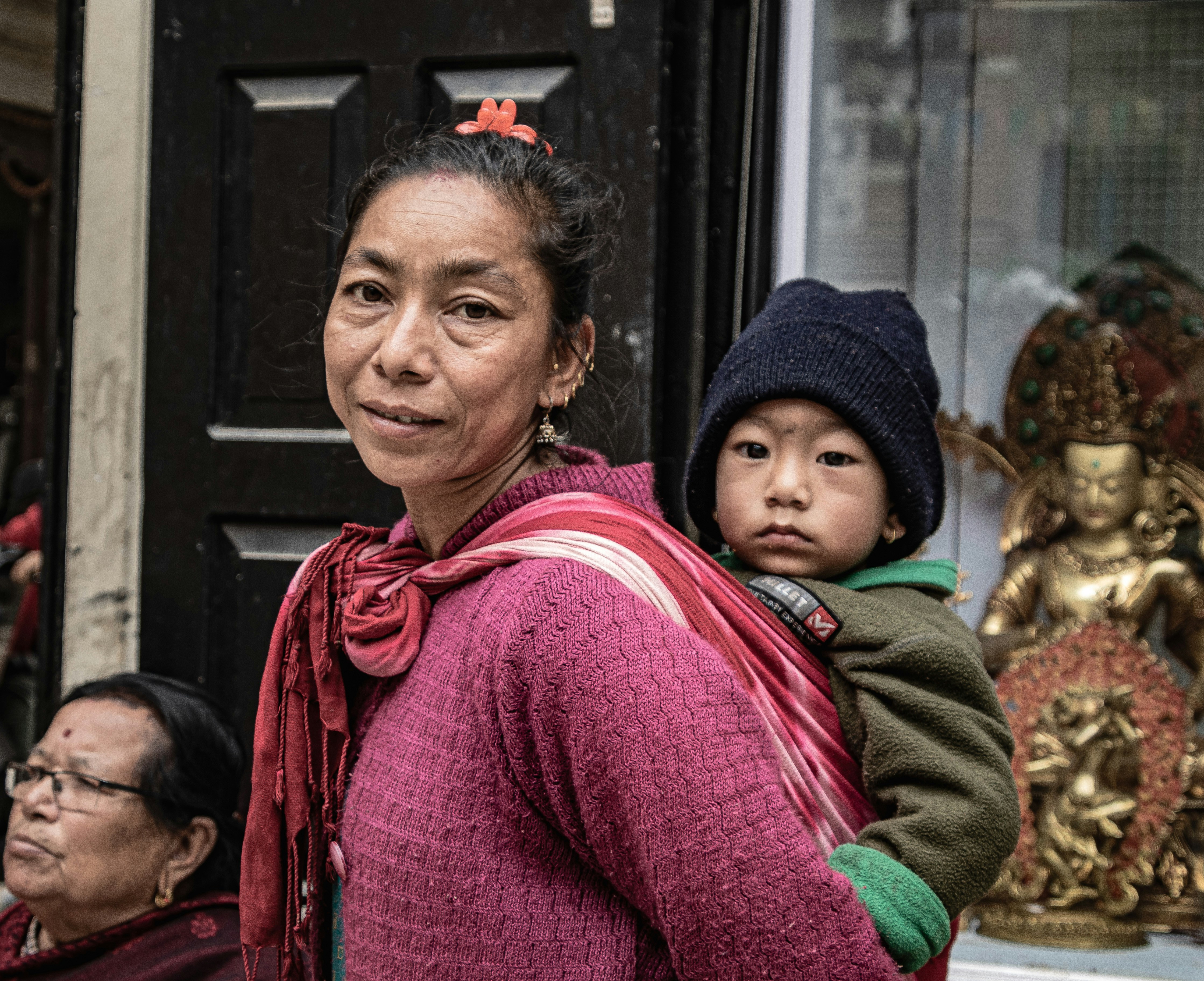 eine Frau, die ein Kind auf dem Rücken trägt