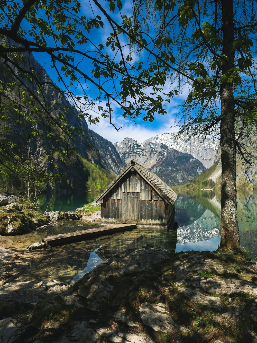 a small cabin sitting next to a body of water